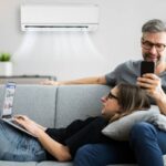 coppia sul divano con condizionatore acceso