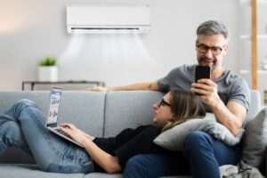 coppia sul divano con condizionatore acceso