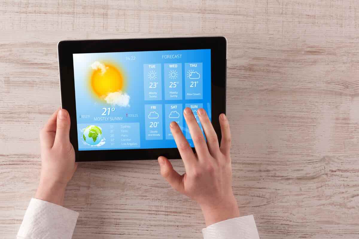 mani su tablet con previsioni meteo