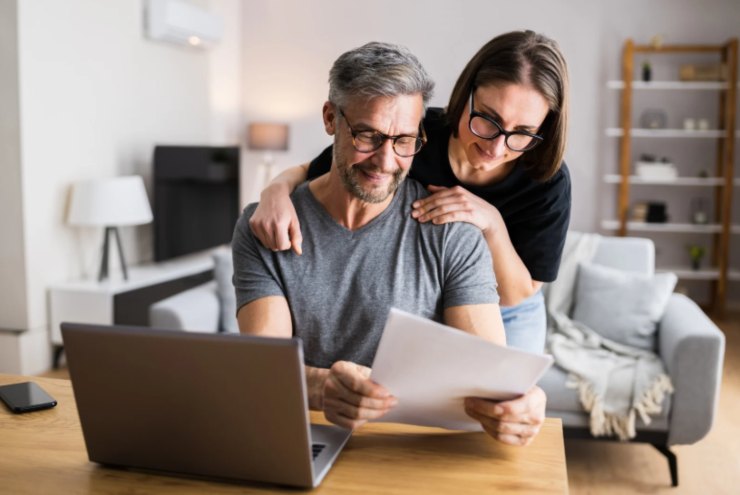 uomo e donna davanti al computer che guardano dei fogli