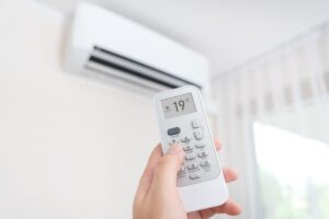 mano con telecomando e condizionatore