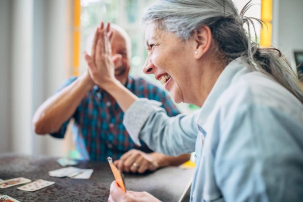 uomo e donna anziani che sorridono e battono il 5 con la mano